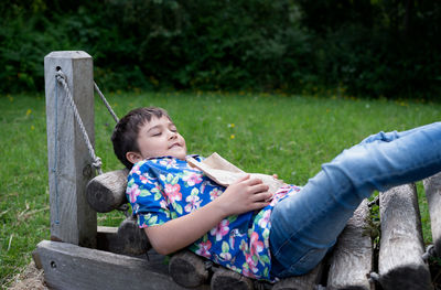 Boy sitting on bench in park