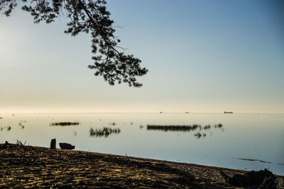 Scenic view of lake against clear sky at sunset