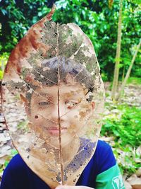 Close-up portrait of man holding plant