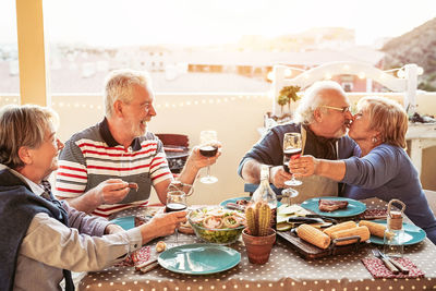 People enjoying food and drinks on table