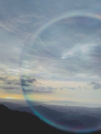 Scenic view of rainbow over landscape against sky