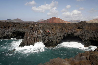 Rock formations by sea against sky