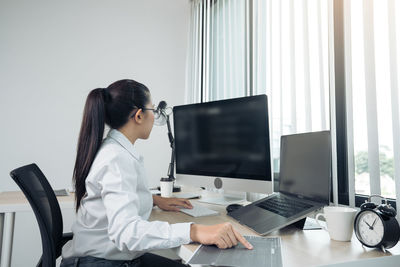 Woman using mobile phone while sitting on table