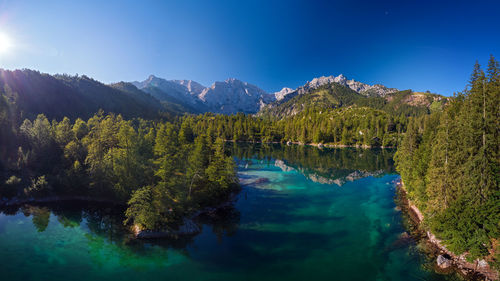 Scenic view of lake by trees against blue sky