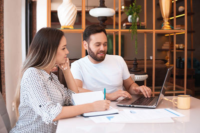 Young woman using laptop at table