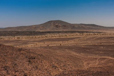 Scenic view of arid landscape against clear sky