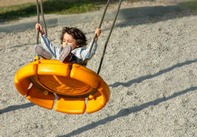 Children playing on swing at playground