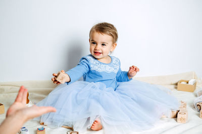 Cute baby girl in blue princess dress playing toys with mom at home. kids dresses for birthday