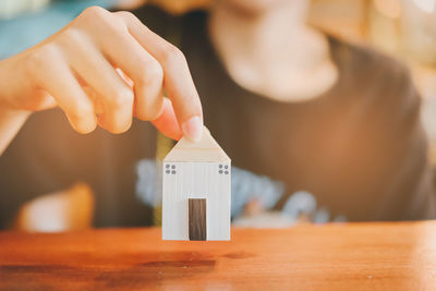 Cropped hands of man holding toy blocks on table