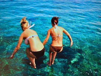 Rear view of friends enjoying in sea