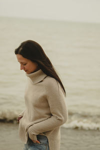 Portrait of young woman standing at beach