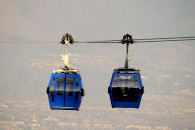 Close-up of overhead cable car against sky