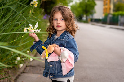 Portrait of cute girl touching flowers in park