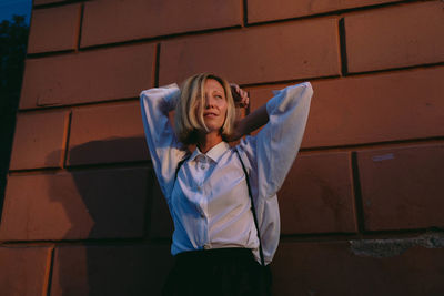 Young woman standing against wall