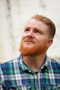 Close-up of man looking away while standing outdoors