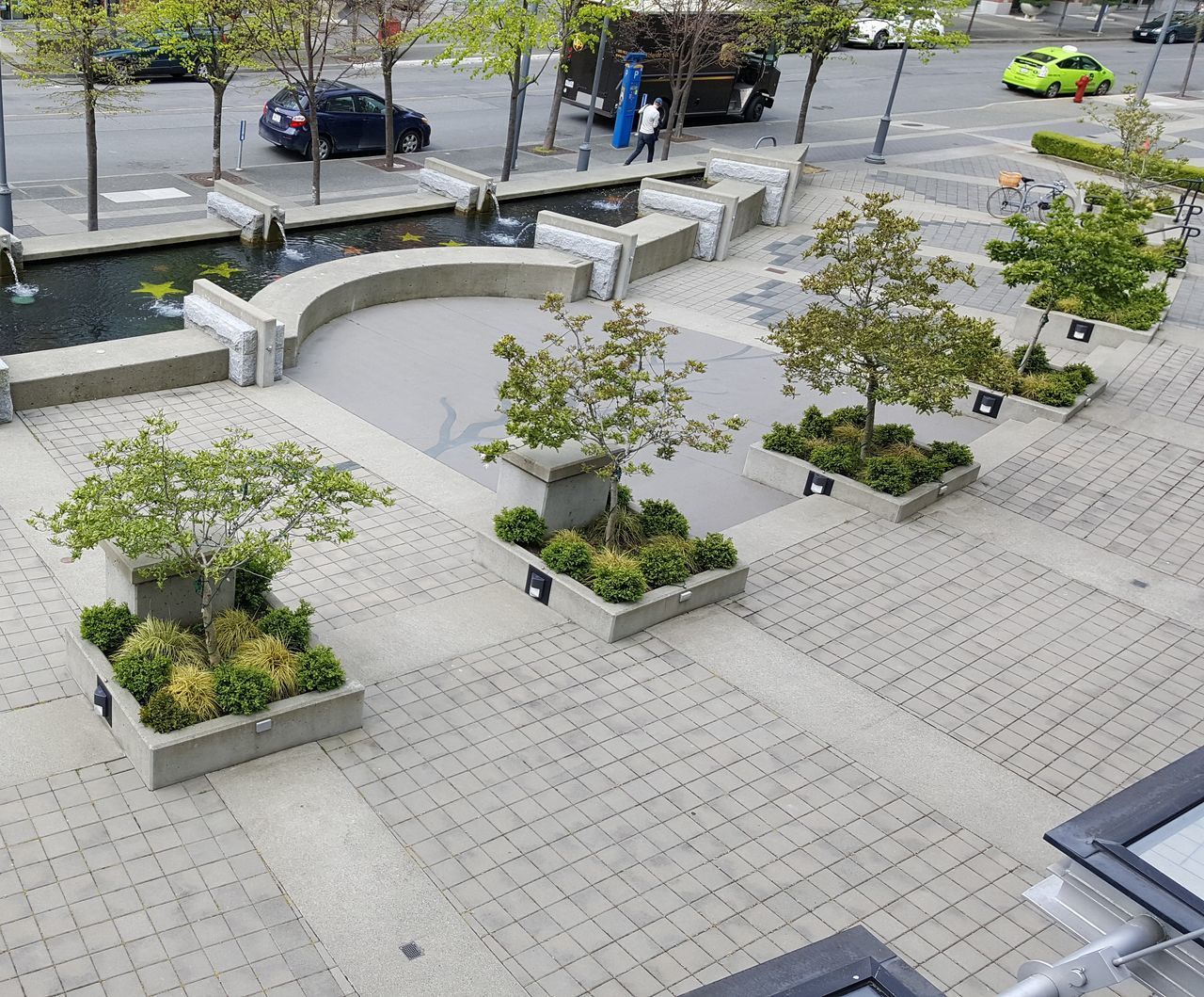 HIGH ANGLE VIEW OF POTTED PLANTS ON FOOTPATH AGAINST BUILDINGS