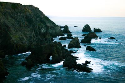 Rocks in sea against sky