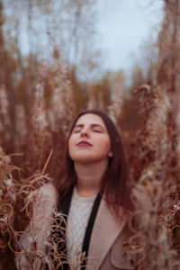 Portrait of a beautiful young woman with eyes closed in the autumn grass