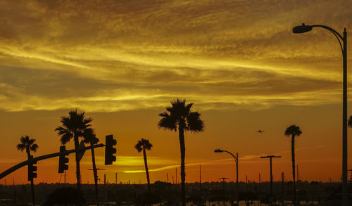 Silhouette palm trees against sky during sunset