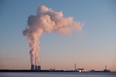 Smoke emitting from chimney against sky