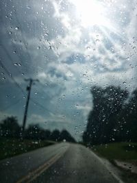 Road seen through wet glass window