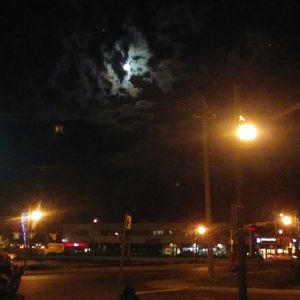 Illuminated street light against sky at night