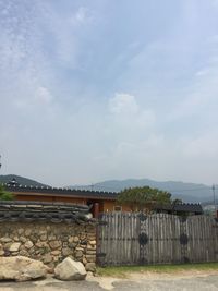 View of bridge by building against sky