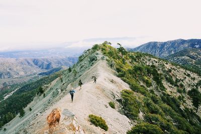 Hikers on mountain peak against sky