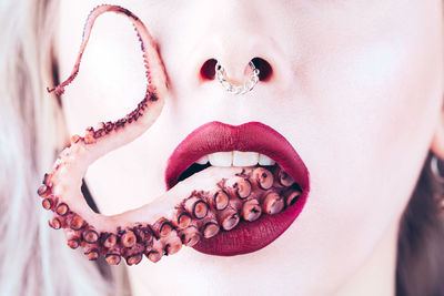 Close-up of woman eating octopus