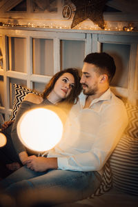 Young couple sitting on bed at home