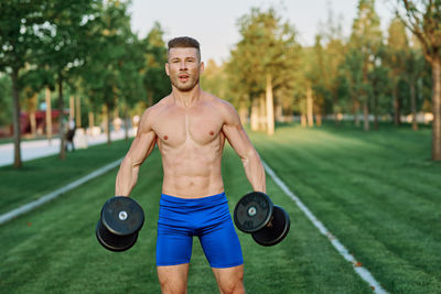 Portrait of shirtless man exercising in park