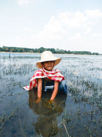 Girl working in agricultural field against sky