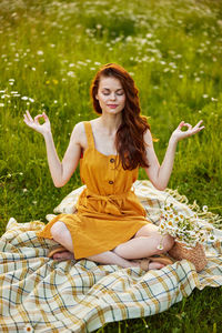 Portrait of young woman sitting on bed at park