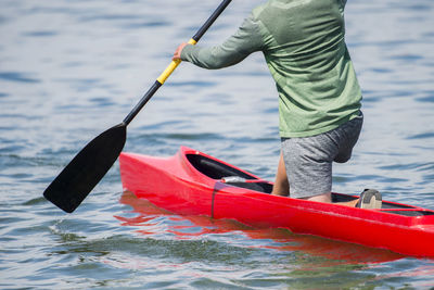 Midsection of man rowing boat in river