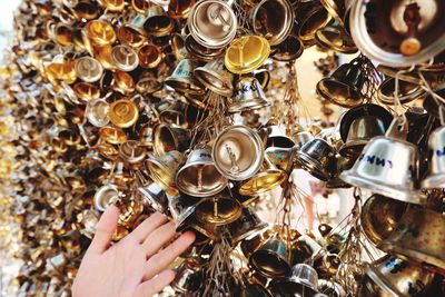 Cropped hand of person touching bells