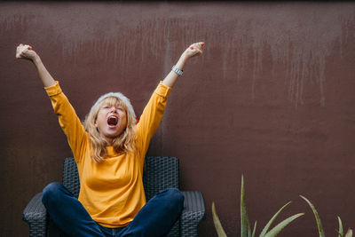 Portrait of young woman sitting on sofa at home
