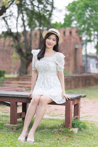 Portrait of young woman sitting on bench