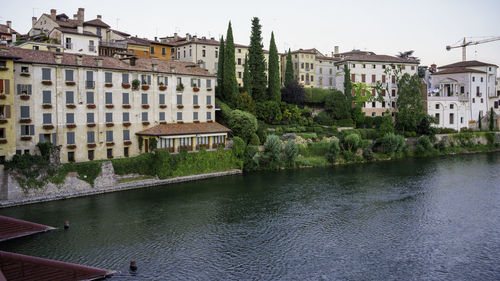 Buildings by river in city