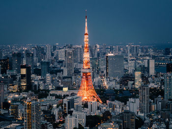 Illuminated buildings in city against sky