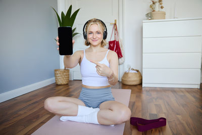 Full length of young woman exercising in gym