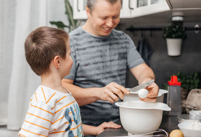 Father and son preparing food at home