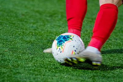 Low section of person with soccer ball on turf grass