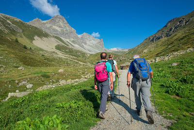 Rear view of people and mountains against sky