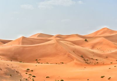 Sand dunes in desert against sky