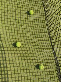 High angle view of tennis balls on grassy field in court