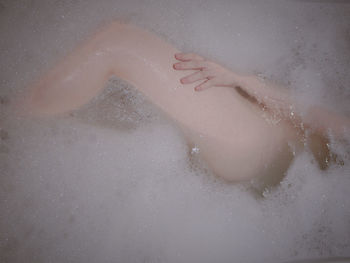 Low section of woman in bathtub