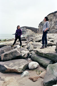 Full length of man standing on rock against sky