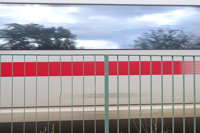 Low angle view of red fence against sky