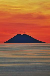 Scenic view of sea against romantic sky and vulcan at sunset