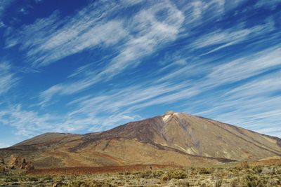 Scenic view of mountains against blue sky